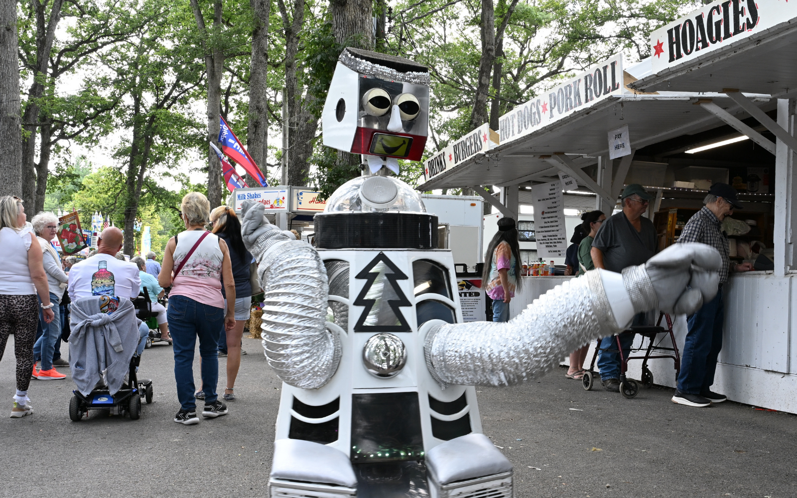 A silver robot character greeting visitors at The West End Fair